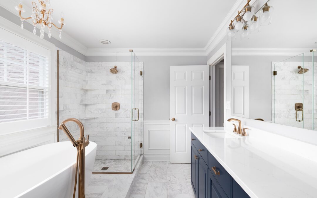 A tidy bathroom with white tile floors, marble countertops, and complimentary copper bathroom hardware