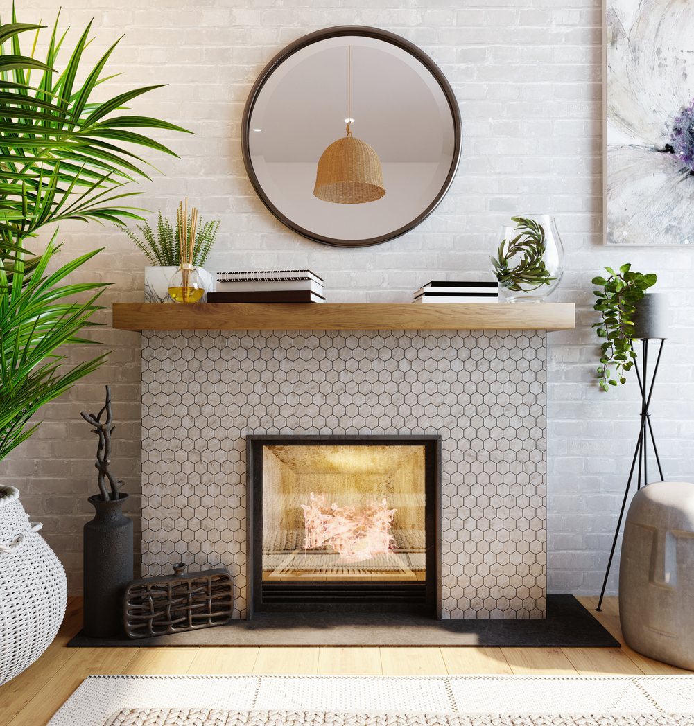A well composed home featuring a tiled fireplace, plants, a mantel with books and incense, and a mirror above the mantel 