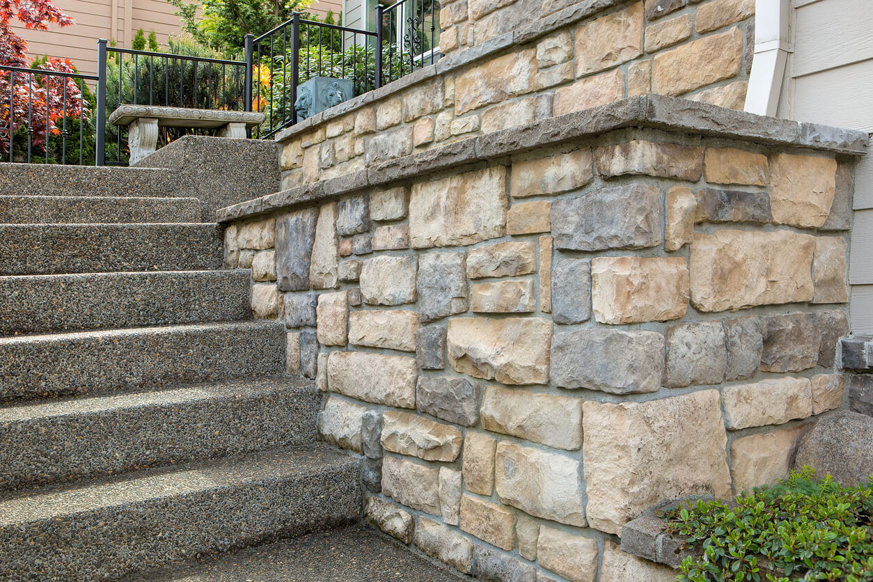 Stone veneer work by the stairs leading up to the front door of a home