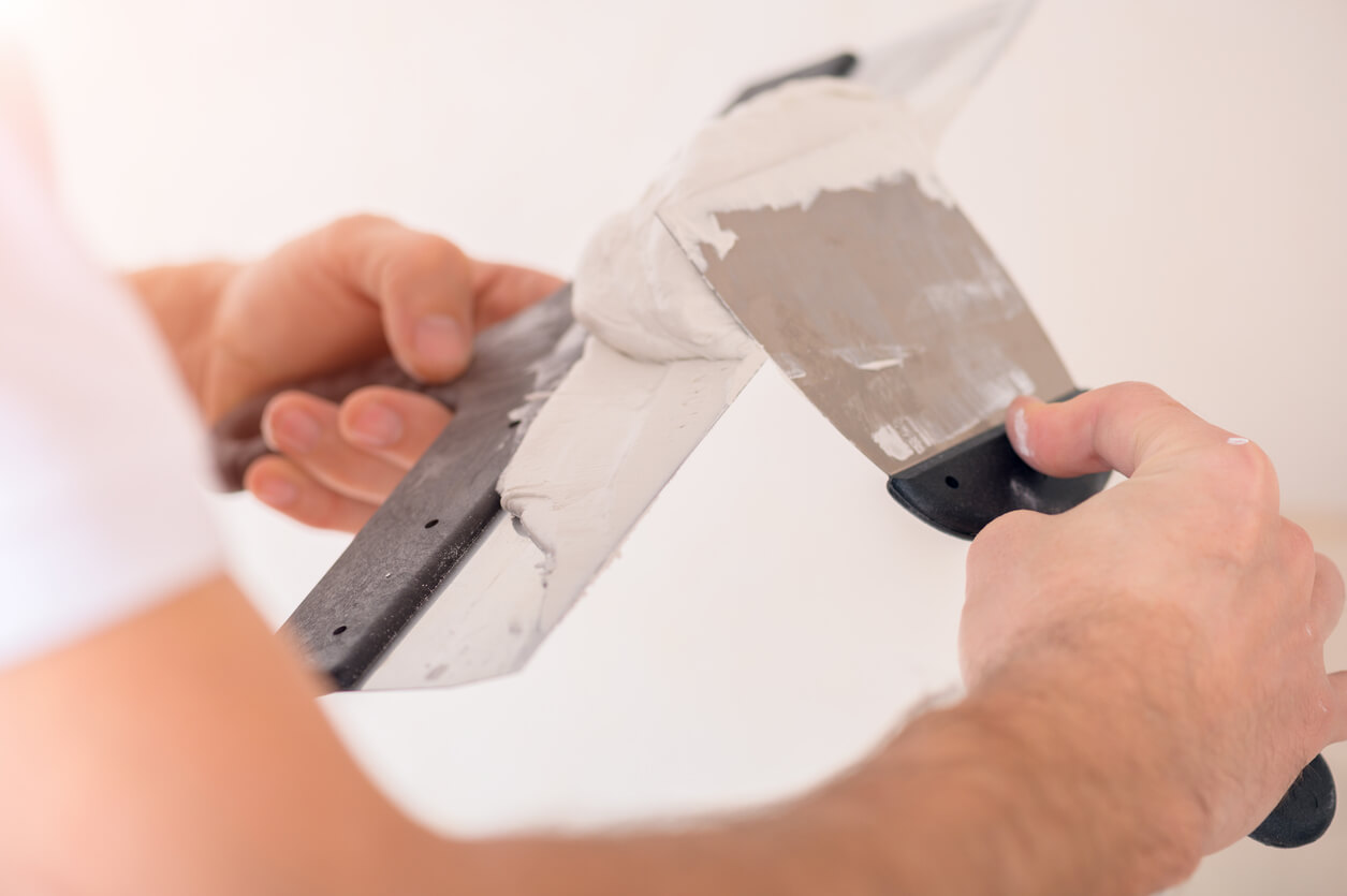 Adding mortar to a trowel before using it to repair stucco or stonework