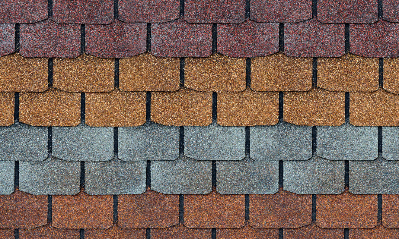 Several colors of roof shingles lined up next to one another to show their differences